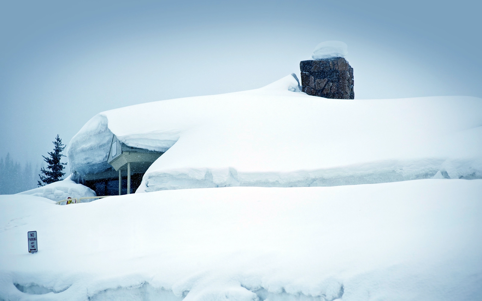 Snow-buried Colorado mountain home roof after a major storm — Vail Valley Home Watch storm preparation and post-storm checks